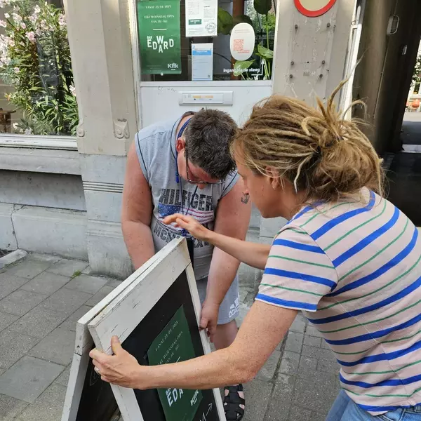 Lies en Maarten zetten het bord van Bar Edward buiten